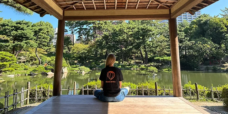 Frau im TourCompass-T-Shirt in einem wunderschönen japanischen Garten in Hiroshima