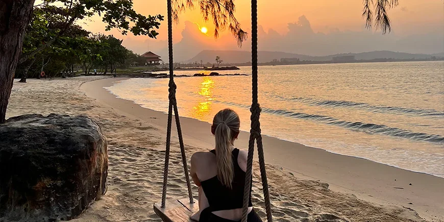 Mädchen auf einer Schaukel beim Sonnenuntergang am Strand von Phu Quoc