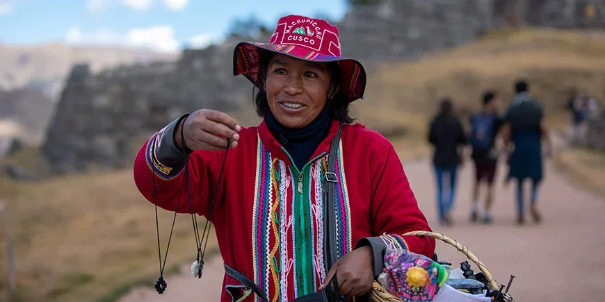 Einheimische Frau in Cusco, Peru, die handgefertigten Schmuck verkauft