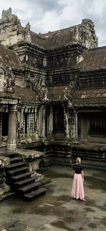 Eine Frau in einem TourCompass-T-Shirt erkundet die Ruinen von Angkor